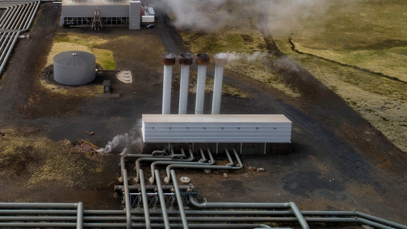 Photo depicts Hellisheidi geothermal powerplant shot from the air in early june, pipes and steam visible