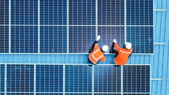 Photo despicts Male engineer installing photovoltaic solar panel system, Electrician or worker mounting solar module technology on roof of power industrial factory, alternative, renewable, sustainable energy. Top. view