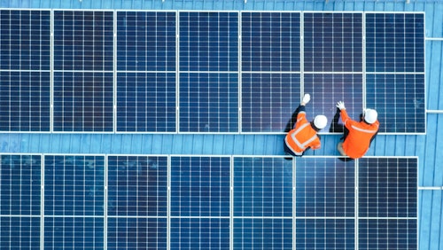 Photo despicts Male engineer installing photovoltaic solar panel system, Electrician or worker mounting solar module technology on roof of power industrial factory, alternative, renewable, sustainable energy. Top. view